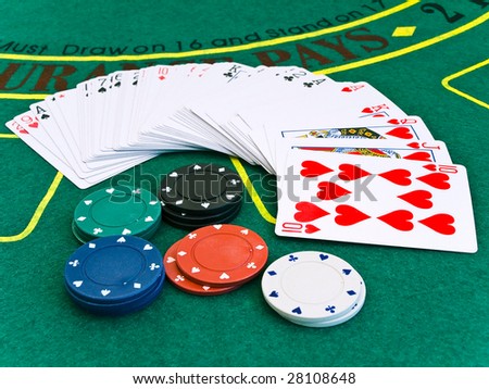 card deck and a few different chips on the playing table in the casino