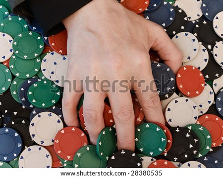 Men's hand on dispersed in casino chips