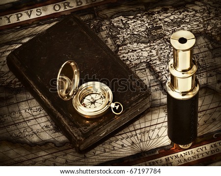 traveling theme: the vintage telescope, compass and an old Bible at antique map