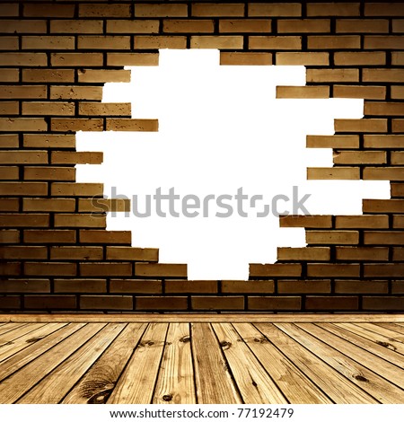 broken hole in the brick wall of room with wooden floor
