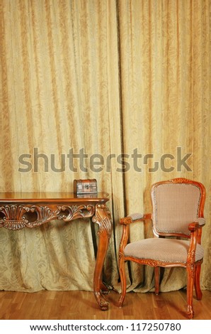 Chair Near The Table In Front Of The Curtained Window