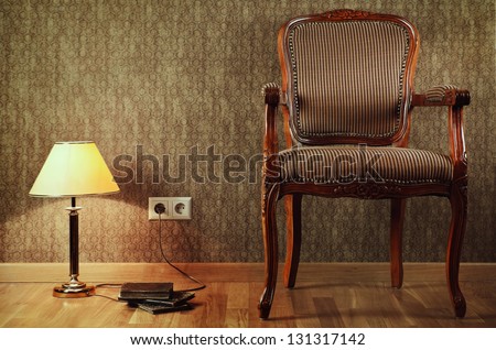 Old Armchair, Desk Lamp And Books On The Floor