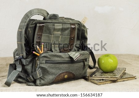 Back To School Theme. Retro Backpack And Apple On The Old Books