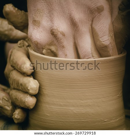 Hands of the Potter in Process of Creation of a Bowl