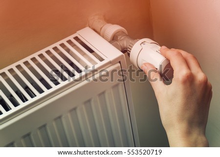 Hand Adjusting The Knob Of Heating Radiator