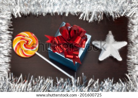Blue gift box, candycane and white christmas star on black wood