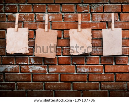 Photo frames with pins on rope over old aged brick wall