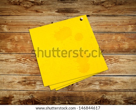 Yellow sticker paper note on vintage wood background