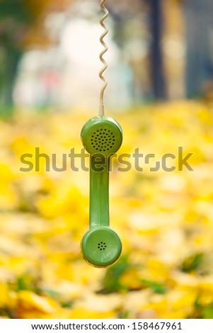 vintage phone receiver hanging in autumn park