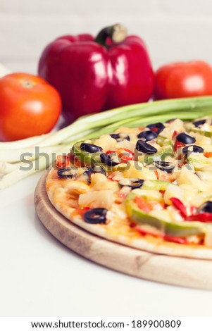Tasty pizza with vegetables, chicken and olives on white