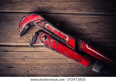 vintage pipe wrench on wooden background