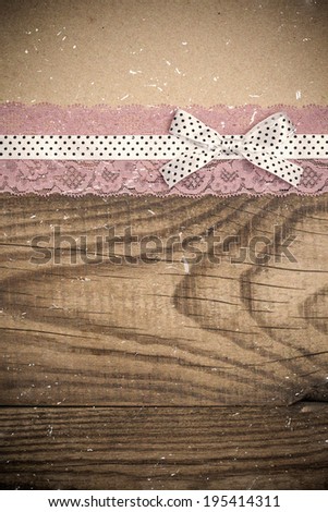 vintage background with wood, old paper and pink and white polka dot ribbon with bow