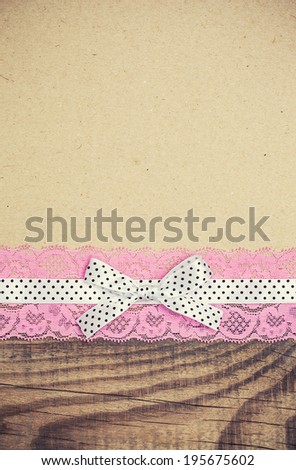 vintage background with wood, old paper and pink and white polka dot ribbon with bow