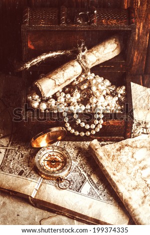 treasure chest, compass and old map on wooden table