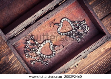 vintage earrings in a form of hearts inside old treasure chest