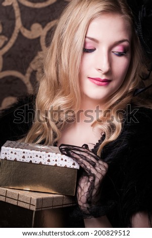 beautiful retro woman holding a golden gift box