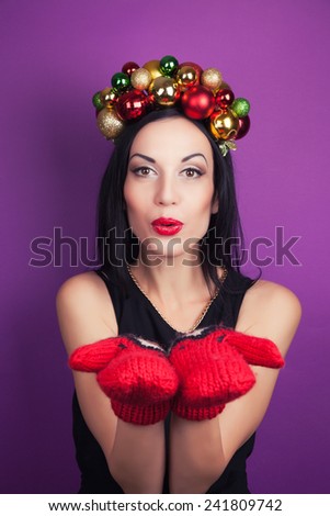 beautiful woman wearing a wreath made from Christmas decorations and red mittens