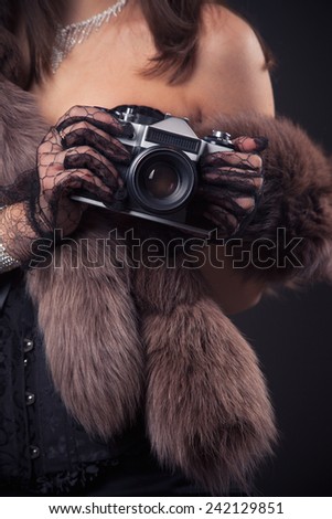 portrait of beautiful young retro woman holding vintage camera
