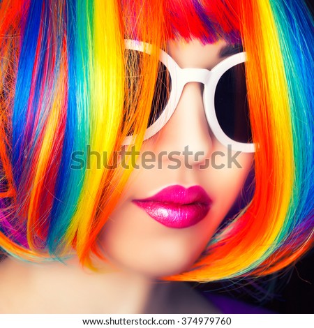 beautiful woman wearing colorful wig and white sunglasses against wooden background