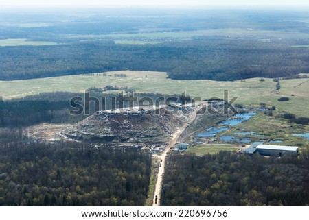 Aerial view of a gigantic hill of garbage contrasted with a green, unspoiled landscape around near Moscow, Russia