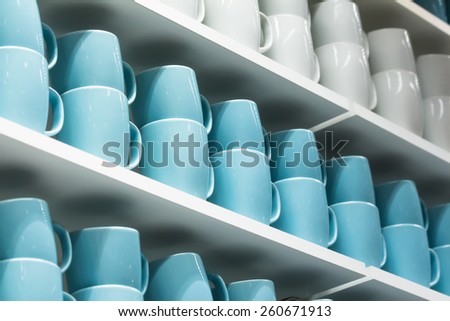White and blue cups on the white shelves in the store