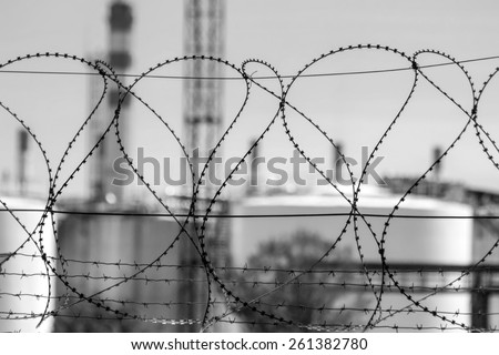 Barbed tape with oil tanks on the background