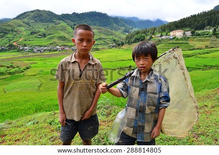 SAPA, VIETNAM - August 10, 2014 : Unidentified Red Dao boys carry a fish net in the Cat cat  village. Red Dao is one of the minority ethnic groups in Vietnam