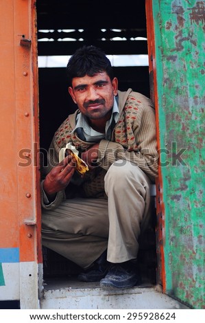 LEH, INDIA. JUNE 24, 2012 : The Indian driver man eating banana between waiting passenger on bus at LEH, North of India