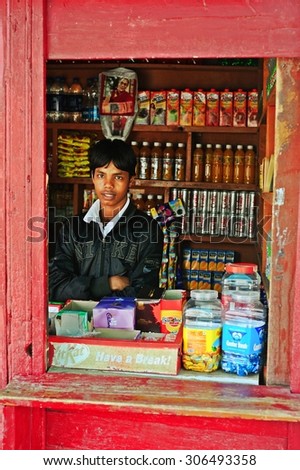 LEH, INDIA. JUNE 13, 2012 : Grocery salesman standing behide the red window in Leh, North of India.