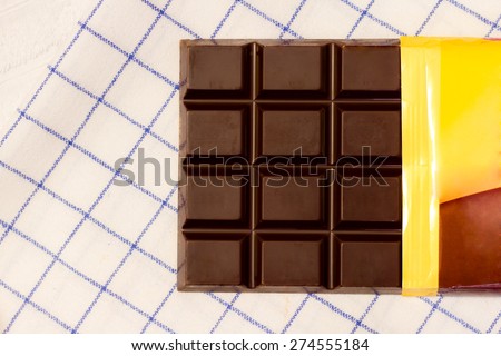 Open bar of chocolate on white fabric