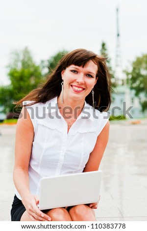 beautiful woman laughs at work with a laptop