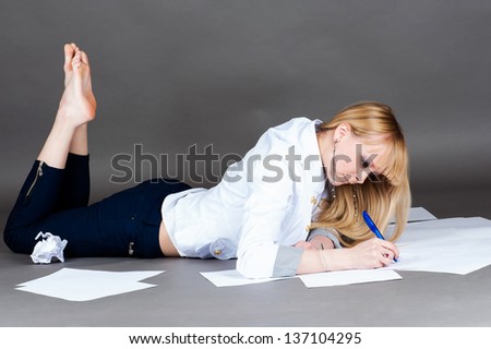 beautiful modern student writes lying on the floor