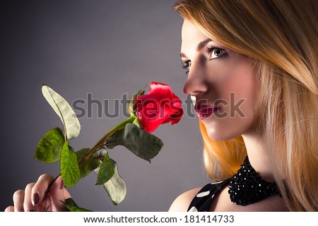 portrait of a beautiful woman smelling a flower