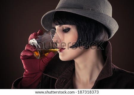 attractive woman detective drinking whiskey from a glass