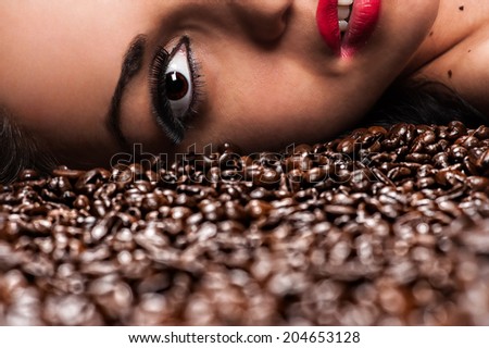 half a woman\'s face with coffee beans