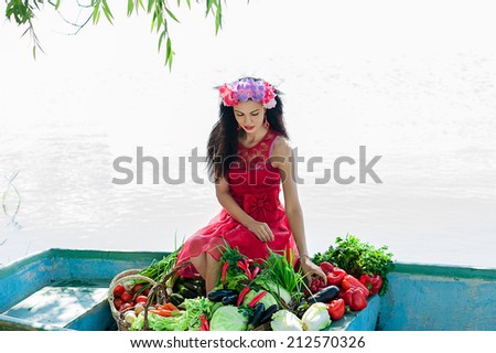 beautiful woman sitting on a boat with vegetables