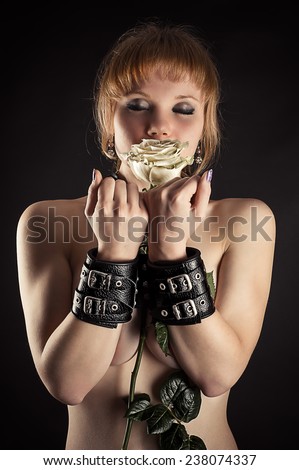 beautiful woman slave in handcuffs with flower in hand