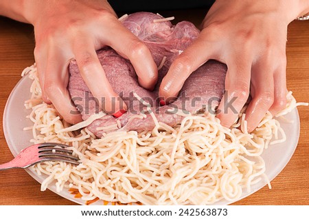 woman hands and raw meat with macaroni
