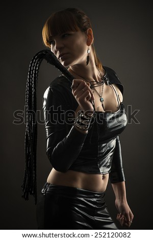 sexy woman with whip in hand isolated on black background