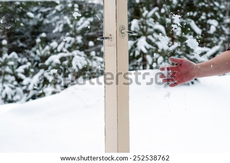 hand throwing snow in the wooden windows