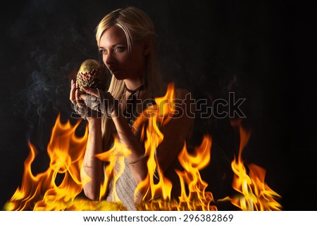 pensive woman with a dragon egg in the fire