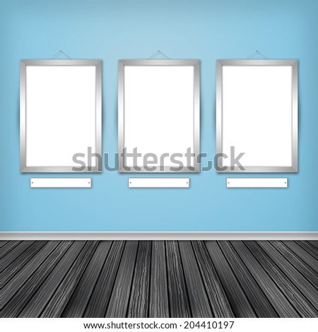 Gallery interior with three empty frames on wall.