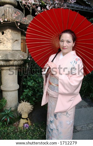Woman with Big Red Umbrella Near Japanese Stone Flashlight.