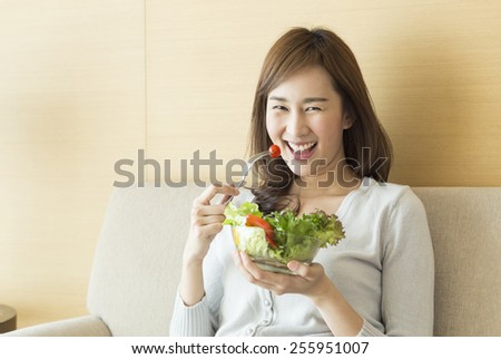 Asian woman eating healthy salad.