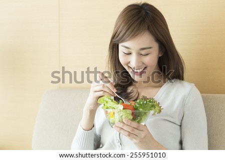 Asian woman eating healthy salad.