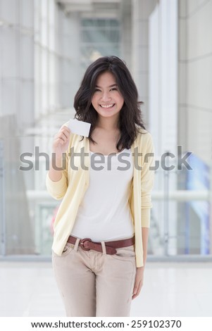 Asian woman holding a card in her hand