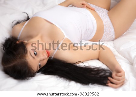 Beautiful young woman on the bed at home