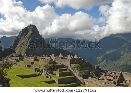 Ancient Inca lost city Machu Picchu landscape with clouds.