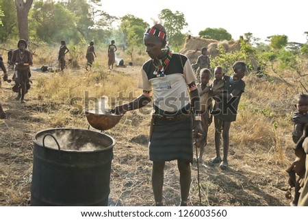 VALLEY OMO, ETHIOPIA - MARCH 12: Unidentified hamer people make traditional beer at the festival dedicated to initiation rite for young men near Dimeka village, March 12, 2012 in Omo Valley, Ethiopia.