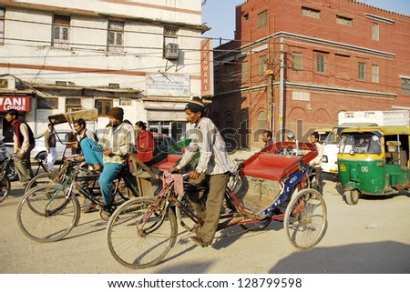 NEW DELHI, INDIA - FEBRUARY 4: Unidentified rickshaw men in a busy Indian street on February 4, 2010 in New Delhi, India. For many of Indians men cycle rickshaw is only way to make 2-3 US $ per day.